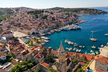 Fototapeta na wymiar Croatian Island Hvar Harbor in Summertime with multiple moored Yachts and boats.