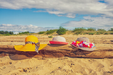 Trzy plażowe kolorowe kapelusze, słoneczny plażowy dzień, piasek.  © Aneta
