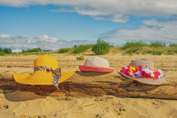 Trzy plażowe kolorowe kapelusze, słoneczny plażowy dzień, piasek. 