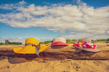 Trzy plażowe kolorowe kapelusze, słoneczny plażowy dzień, piasek. 