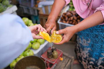 Obraz na płótnie Canvas hand cutting citrus fruit with knife