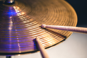 Close-up of drumsticks on a cymbal drum.