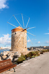 Colorful panoramic view of windmills with yachts in Mandraki harbor at sunset, Rhodes Greece. High quality photo