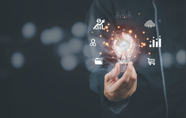 Businessman holding a light bulb for a smart industrial concept. AI technology, innovation and technology inspiration, innovation in science concepts and communicating the future world.