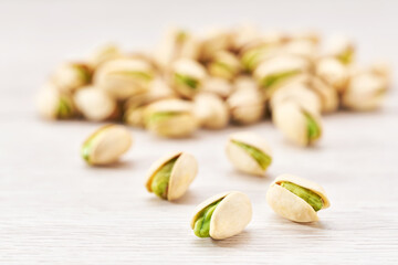 pistachios spill out on a white table, selective focus.