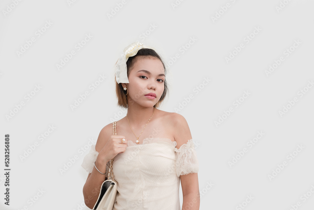 Poster A young woman wearing a white lace dress and a bow on her hair standing proud isolated on a white background.