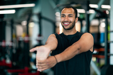 Warming Up. Young Handsome Black Male Athlete Stretching Arm Muscles At Gym