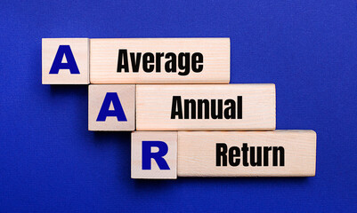 Obraz premium On a bright blue background, light wooden blocks and cubes with the text AAR Average Annual Return