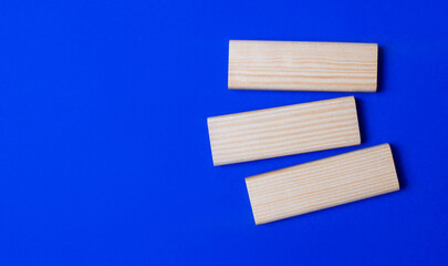 Three wooden blocks with space to insert text on a blue background. Copy space