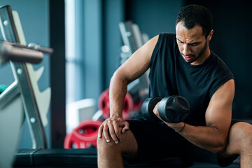 Portrait Of Motivated Black Sportsman Lifting Heavy Dumbbell With One Hand