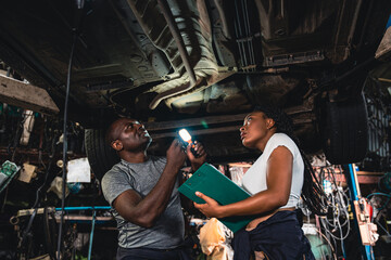 Two mechanic was checking the car suspension.