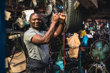 Professional mechanic checking the problem tires thoroughly in the garage.
