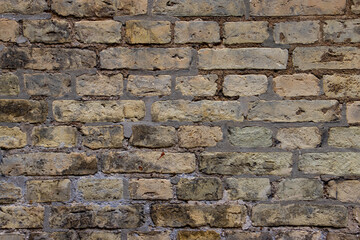 Old weathered beige brown brick wall background