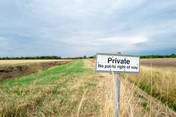 Shallow focus of a No Public Right of Way sign seen on farm land. Located near a public footpath,...