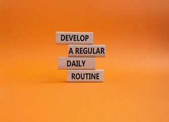 Develop a regular daily routine symbol. Concept words Develop a regular daily routine on wooden blocks. Beautiful orange background. Business and Develop a regular daily routineconcept. Copy space.