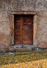 an old wooden door in the middle of a stone wall - 528262097