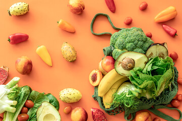 Fresh fruits and vegetables on a colored background, flat lay.