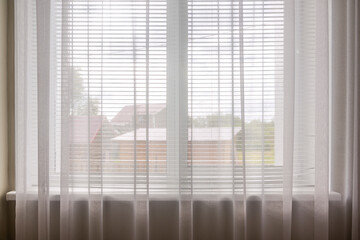 background window in the room with curtains and tulle