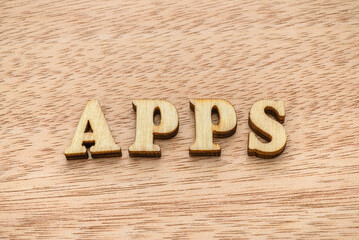 Wooden letter spelling the word APPS on wooden background.