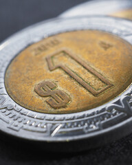 Coin of 1 Mexican peso closeup. Peso of Mexico. News about economy or banking. Loan and credit. Wages and money. Focus on peso symbol. Vertical stories. Macro
