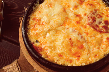 Baked tomatoes with Suluguni cheese , Ketsi in a clay pan , Georgian dish, homemade, top view, on a wooden table, no people,