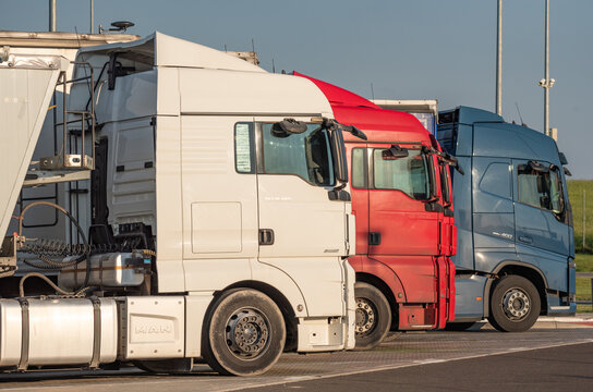 Mazowieckie, Poland - June 3, 2022: Trucks in a parking lot by the light of the setting sun. Road transport in Europe.