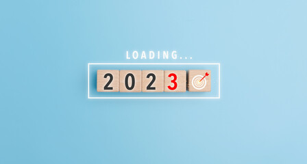 Start new year 2023 setting goal plan, target concept, strategy, new year business vision. Loading 2023 of New Year. Loading bar with wooden blocks 2023 on blue background..