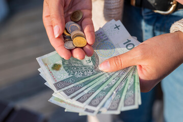 the girl holds in her hands banknotes money polish zlotys and pennies coins salary for payment