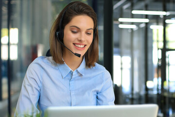 Woman customer support operator with headset and smiling.
