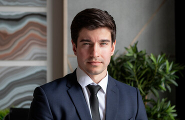 portrait of young businessman in a dark blue suit working in the office