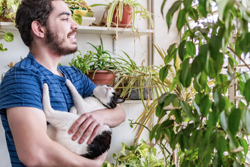 Man with cat staring through the window.