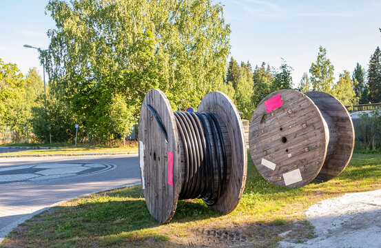 Wooden spools, cable reels, stacked up for storage in an industrial park -  a Royalty Free Stock Photo from Photocase