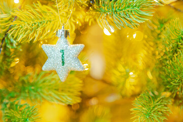 Weihnachtsschmuck (Stern) am Baum mit einer Zahl (1) vom Weihnachtskalender