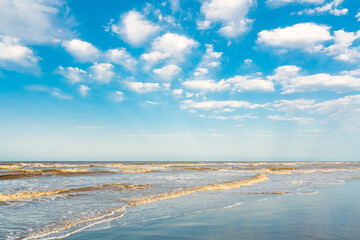 Wavy sea and blue sky with clouds