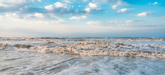 Waves on beach and blue sky with clouds landscape