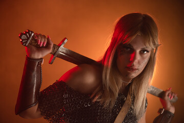 Woman warrior with the sword in hands close up.