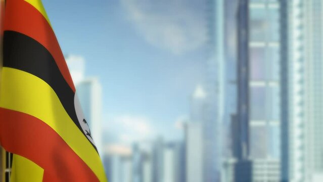 hanging Uganda flag on city backdrop with blue sky