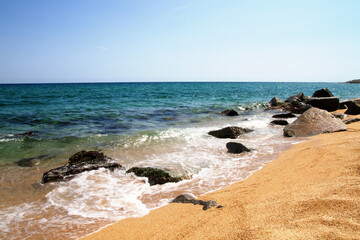 Fototapeta na wymiar Waves, sea, beach, clear water. Stones under water. Spain.