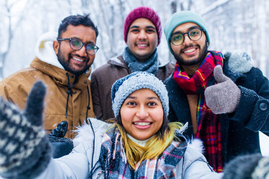 four people taking selfie shot outdoors at new year holidays