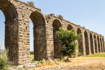 Fototapeta na wymiar Aqueduct in Aspendos. Turkey. Ruin. An ancient Roman aqueduct that supplied Aspendos with water. Arched structure. 
