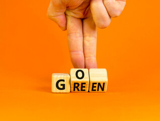 Ecology and go green symbol. Concept words Go green on wooden cubes. Businessman hand. Beautiful orange table orange background. Business ecological and go green concept. Copy space.