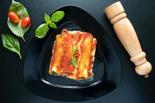Cannelloni served in a dish isolated on dark background top view of italian food
