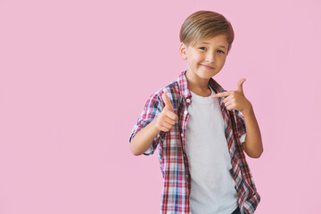 Young happy teen boy with in casuals on pink background.