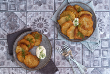 Classic potato pancakes with sour cream sauce served on a gray ceramic dish. Traditional belarusian potato pancakes draniki. Top view.