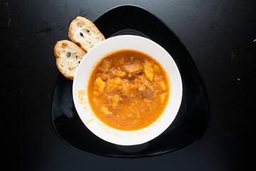 Spezzatino Alla Mianese with bread served in a dish isolated on dark background top view of italian food