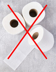 Concept of abandoning disposable toilet paper due to rising costs in crisis, toilet paper rolls crossed with a red cross