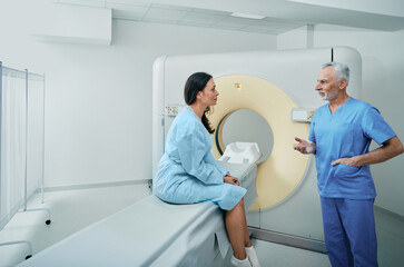Computed Tomography. Medical professional talking with female patient in hospital radiology...
