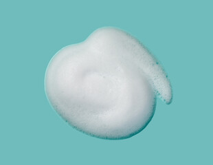 Fototapeta premium Foam lather texture background. White cleanser gel, shaving foam, shampoo bubbles on blue.