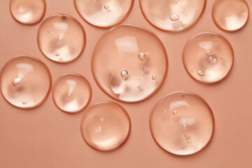 Cosmetic serum gel beauty drop on pink color background. Skincare beauty product with bubbles texture.	