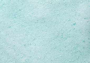 Foam lather texture background. White cleanser gel, shaving foam, shampoo bubbles on blue.